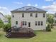Rear exterior of home features a wooden deck, manicured lawn, and solar panels, blending comfort and sustainability at 449 Sandy Whispers Pl, Cary, NC 27519