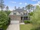 Charming two-story home featuring a stone facade, front porch, attached garage, and landscaped front yard at 449 Sandy Whispers Pl, Cary, NC 27519