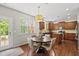Eat-in kitchen features stainless appliances, an island, and hardwood floors around a table and four chairs at 449 Sandy Whispers Pl, Cary, NC 27519