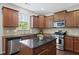 Stylish kitchen with stainless steel appliances, granite countertops, an island, and abundant cabinet space at 449 Sandy Whispers Pl, Cary, NC 27519