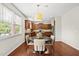 Eat-in kitchen features stainless appliances, an island, and hardwood floors around a table and four chairs at 449 Sandy Whispers Pl, Cary, NC 27519