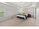 Large main bedroom with tray ceiling, neutral walls, carpet, bedside tables, and two windows with blinds at 449 Sandy Whispers Pl, Cary, NC 27519