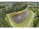Aerial view of a community pond with a fountain and walking path at 449 Sandy Whispers Pl, Cary, NC 27519