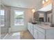 Bright bathroom featuring a glass enclosed shower, double vanity and a window providing natural light at 45 Addison Pond Ct # 11, Zebulon, NC 27597