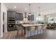 Stylish kitchen with gray cabinets, quartz countertops, an island with bar seating and stainless appliances at 45 Addison Pond Ct # 11, Zebulon, NC 27597