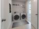Well-lit laundry room featuring a washer, dryer, storage shelves, and neutral decor at 45 Addison Pond Ct # 11, Zebulon, NC 27597