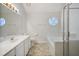 Bright bathroom showcasing a large vanity, tub and a unique round window at 4500 Hollirose Pl, Raleigh, NC 27616