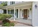 Close up front view of the covered porch with decorative wood door and green shutters at 4500 Hollirose Pl, Raleigh, NC 27616