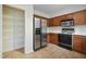 Kitchen featuring stainless steel refrigerator, a gas range, wood cabinetry, and tile flooring at 4500 Hollirose Pl, Raleigh, NC 27616