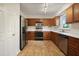 Bright kitchen boasts stainless appliances, wood cabinets, and tile flooring at 4500 Hollirose Pl, Raleigh, NC 27616