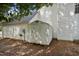 View of a metal shed against the white exterior of the home in a leaf covered yard at 4500 Hollirose Pl, Raleigh, NC 27616