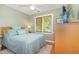 Cozy bedroom with a bed, green walls, a ceiling fan, wood floors, an area rug, and a window at 53 Westridge Dr, Durham, NC 27713