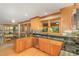 Kitchen with wood cabinets, granite countertops, stainless steel appliances, and a garden view at 53 Westridge Dr, Durham, NC 27713