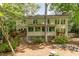 View of rear exterior of two-story home with wood siding, lots of windows and a small deck with wooden stairs at 53 Westridge Dr, Durham, NC 27713