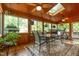 Bright sunroom with wood floors, multiple windows, skylights, a ceiling fan, and a dining table at 53 Westridge Dr, Durham, NC 27713
