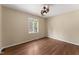 Inviting bedroom with hardwood floors, a ceiling fan, and a bright window at 5713 Timber Ridge Dr, Raleigh, NC 27609
