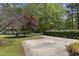 Long driveway leading to a house with mature trees and manicured landscaping at 5713 Timber Ridge Dr, Raleigh, NC 27609