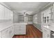Bright and airy kitchen with white cabinets, hardwood floors, and built-in shelving at 5713 Timber Ridge Dr, Raleigh, NC 27609