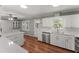 Open kitchen featuring white cabinetry, stainless steel appliances, and access to a patio at 5713 Timber Ridge Dr, Raleigh, NC 27609
