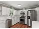 Modern kitchen with stainless steel appliances, white cabinets, and plenty of counter space at 5713 Timber Ridge Dr, Raleigh, NC 27609