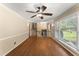 Spacious living room with hardwood floors, fan, and large windows offering natural light at 5713 Timber Ridge Dr, Raleigh, NC 27609