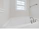 Bright bathroom featuring a soaking tub, brushed nickel faucet, window, and a towel bar at 60 Rosewood Ln, Youngsville, NC 27596