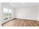 Sunlit bedroom with large window, light hardwood floors, and neutral walls, creating a serene atmosphere at 60 Rosewood Ln, Youngsville, NC 27596