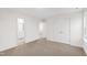 Bedroom with neutral carpet, a view into an adjacent bathroom, and closet with double doors at 60 Rosewood Ln, Youngsville, NC 27596