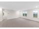 Bright bonus room with neutral carpet, two windows, and an open doorway at 60 Rosewood Ln, Youngsville, NC 27596