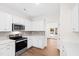 Kitchen features stainless steel appliances, gray subway tile backsplash, and wood floors at 60 Rosewood Ln, Youngsville, NC 27596