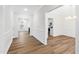 Open-concept living space with light hardwood floors and white trim, flowing into the dining area and kitchen at 60 Rosewood Ln, Youngsville, NC 27596
