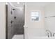Main bathroom featuring a walk-in shower, soaking tub, and a bright window at 60 Rosewood Ln, Youngsville, NC 27596