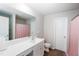 Bathroom with a long vanity, a mirror, and a toilet. It features neutral walls and dark wood flooring at 608 Crackling Ct, Zebulon, NC 27597