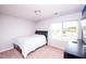 Bedroom with a small bed and black night stand on a carpeted floor and a window with a view at 608 Crackling Ct, Zebulon, NC 27597