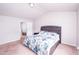 Primary bedroom with a queen bed, gray headboard, neutral walls and carpet at 608 Crackling Ct, Zebulon, NC 27597