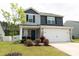 Charming two-story home features stone accents, gray siding, a two-car garage, and a manicured front yard at 608 Crackling Ct, Zebulon, NC 27597