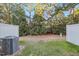 Serene backyard features green grass, tall trees, privacy fence, and AC unit at 6323 Pesta Ct, Raleigh, NC 27612