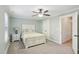 Charming bedroom with a white bed frame, ceiling fan, carpeted floors, and a light blue wall at 6323 Pesta Ct, Raleigh, NC 27612