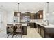 Modern kitchen with stainless steel appliances, dark cabinets, and a breakfast bar with seating at 6323 Pesta Ct, Raleigh, NC 27612