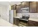 Modern kitchen featuring stainless steel appliances, dark cabinets, and white countertop at 6323 Pesta Ct, Raleigh, NC 27612