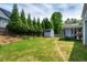 View of the lush backyard featuring green grass, mature trees, and a storage shed at 6901 Rex Rd, Holly Springs, NC 27540