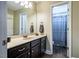 This bathroom boasts a large mirror, a sink with dark cabinets, and a shower with a blue curtain at 6901 Rex Rd, Holly Springs, NC 27540