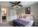 This bedroom features a ceiling fan, a door to the bathroom, and a bed with striped bedding and decorative pillows at 6901 Rex Rd, Holly Springs, NC 27540