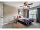 This bedroom features a ceiling fan, a window, and a bed with striped bedding and decorative pillows at 6901 Rex Rd, Holly Springs, NC 27540