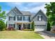 Beautiful two-story home with blue siding, black shutters, manicured lawn, and an attached two-car garage at 6901 Rex Rd, Holly Springs, NC 27540