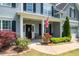 Charming front porch with stone accents, black door, and beautiful landscaping at 6901 Rex Rd, Holly Springs, NC 27540
