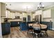 Well-lit kitchen with white cabinets, dark countertops, an island, and stainless appliances at 6901 Rex Rd, Holly Springs, NC 27540