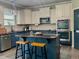 Modern kitchen with sleek countertops, an island with stools, and stainless steel appliances at 6901 Rex Rd, Holly Springs, NC 27540