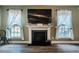 Living room with wood floors, fireplace, and large windows at 6901 Rex Rd, Holly Springs, NC 27540