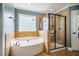 A luxurious main bathroom featuring a tub and glass-enclosed shower at 6901 Rex Rd, Holly Springs, NC 27540